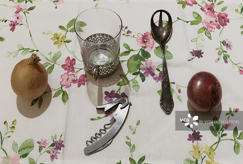 两个洋葱、一个玻璃杯、一把勺子和一个开瓶器图片素材