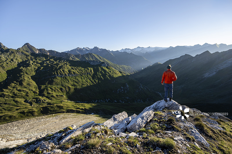 登山者在日出时分的山景前，俯瞰维尼迪格山脉的山峰和格罗斯巴赫塔尔谷，从巴赫伦肯科夫峰顶俯瞰，拉索尔林山脉，霍赫陶恩国家公园，东蒂罗尔，蒂罗尔，奥地利，欧洲图片素材