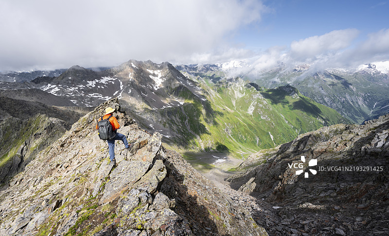 登山者在陡峭的岩石山脊上，站在拉索尔林峰的顶峰，俯瞰维尼迪格山群、拉索尔林山群和高塔恩国家公园的山脉全景，东蒂罗尔，蒂罗尔，奥地利，欧洲图片素材