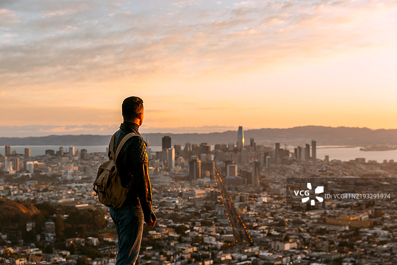 男子在加利福尼亚州旧金山的双峰山上观看日出图片素材