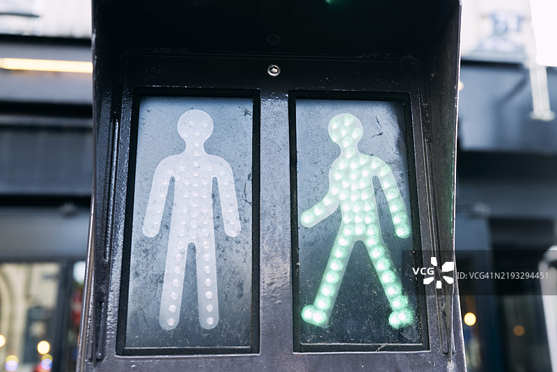 交通信号灯的正面特写，前景中有绿色人形图案，周围没有人。图片素材