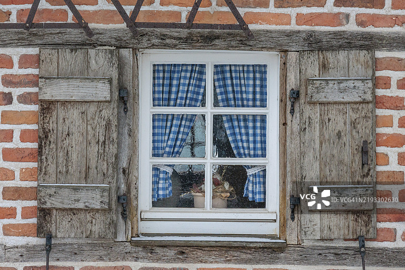 雪中的窗户特写，配有蓝色格子窗帘和木百叶窗，地点：韦塞克，博尔肯，明斯特兰，北莱茵-威斯特法伦，德国，欧洲图片素材
