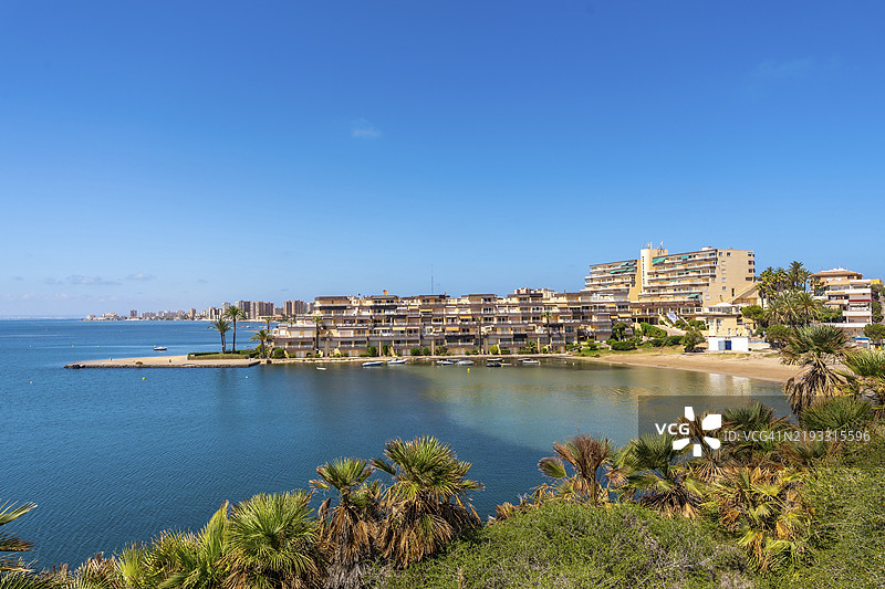 西班牙穆尔西亚的卡拉德尔皮诺，风景如画的夏季景色，展示了拉曼加德尔马尔莫农的住宅建筑、宁静的水面和湛蓝的天空。图片素材