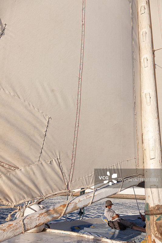 在埃及尼罗河上，日落时分，水手在小帆船上放松。图片素材