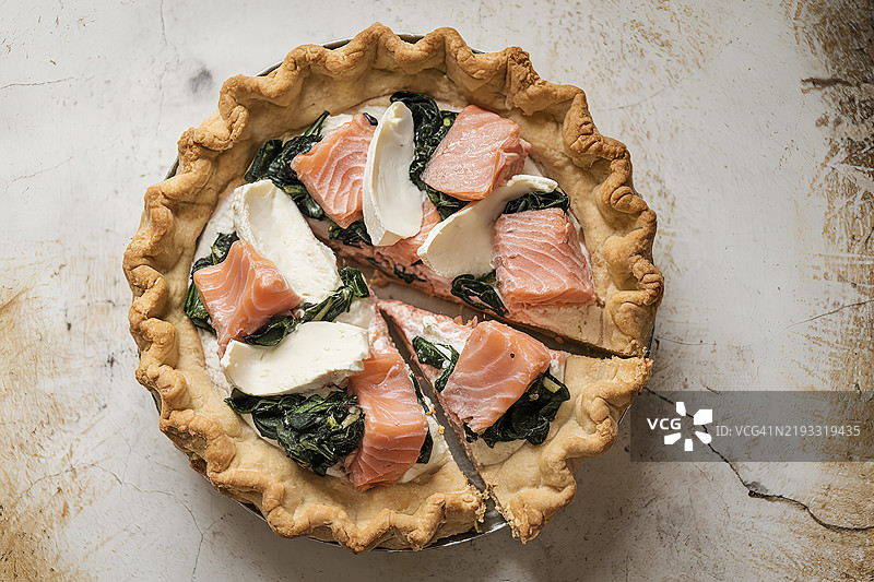 一款乡村风格的白色派，里面有三文鱼块、菠菜和软奶酪。图片素材