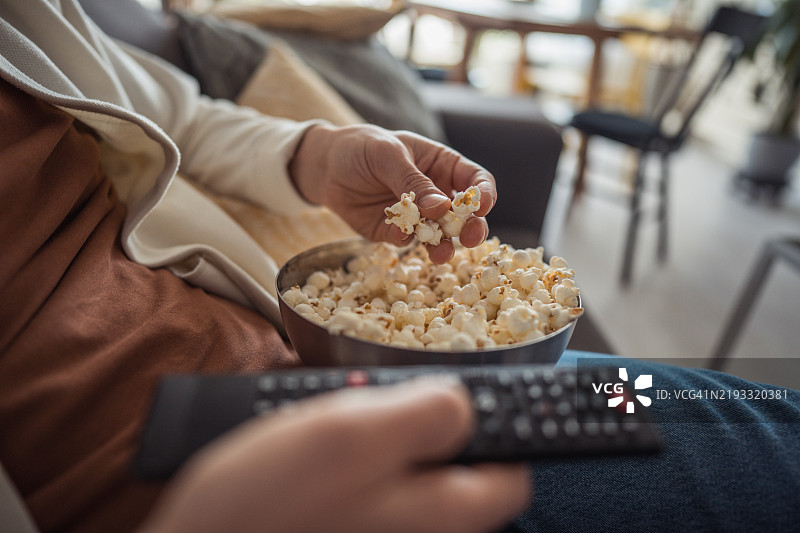 一个男人舒适地坐在沙发上看电视图片素材