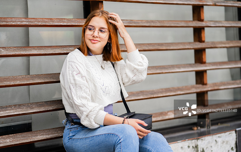 女人坐在户外城市环境中的墙上图片素材