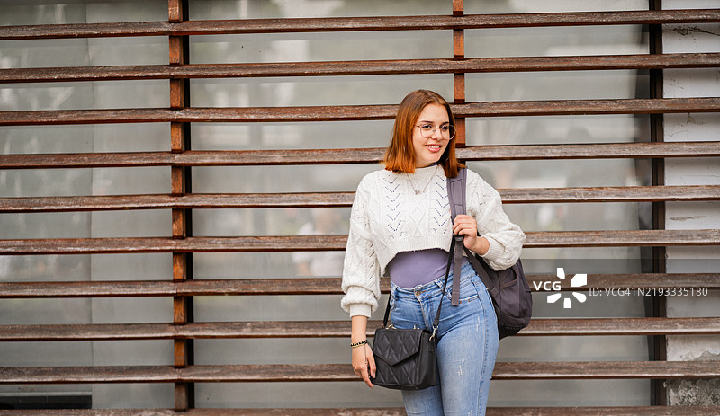 短发女大学生在校园户外背着书包走路图片素材