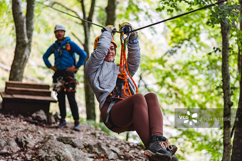 在教练监督下的森林滑索冒险图片素材