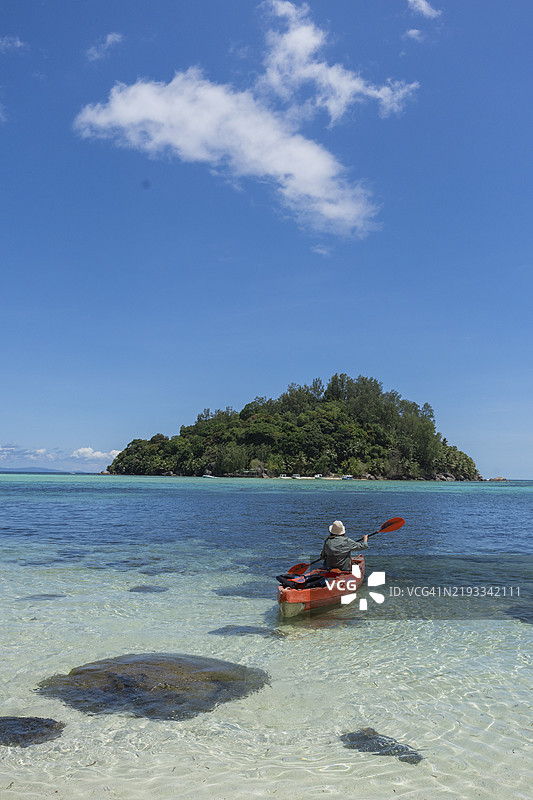 年轻女性在热带泻湖划皮划艇图片素材