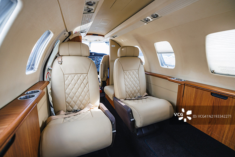 豪华私人飞机内部，配有优雅的皮革座椅图片素材