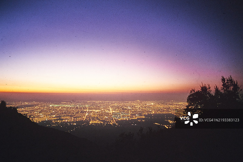 黄昏时分，山顶的城市灯光照亮了暮色。图片素材