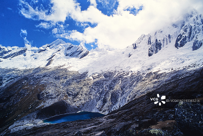 令人惊叹的冰川湖泊坐落在白色山脉的雪峰之间图片素材