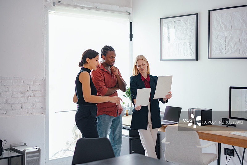 年轻同事在现代办公室环境中讨论设计项目图片素材