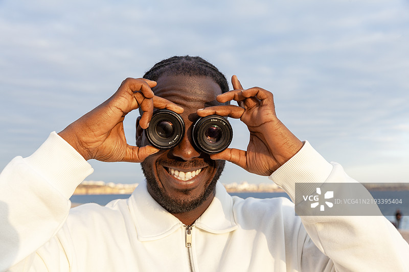 非洲裔男子手持镜头对着眼睛图片素材