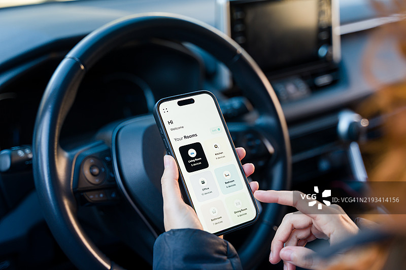 女性在车内通过智能手机应用控制智能家居设备图片素材