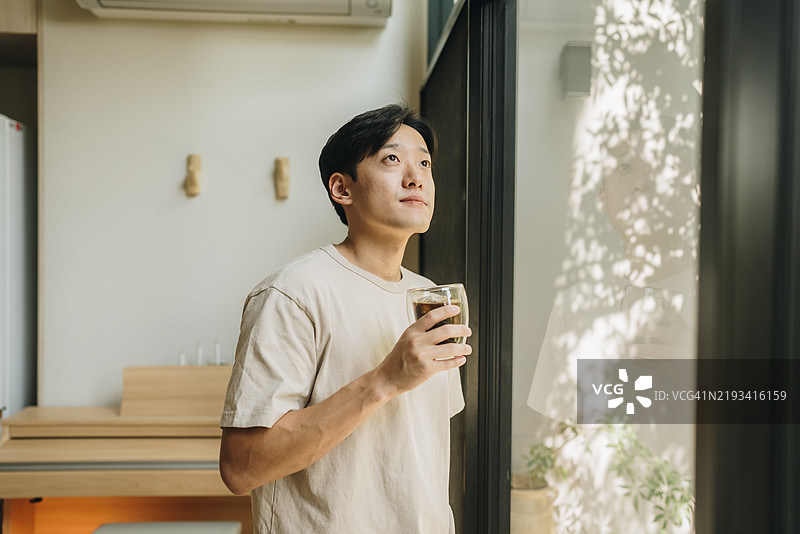 男人在沉思时喝咖啡和茶。图片素材