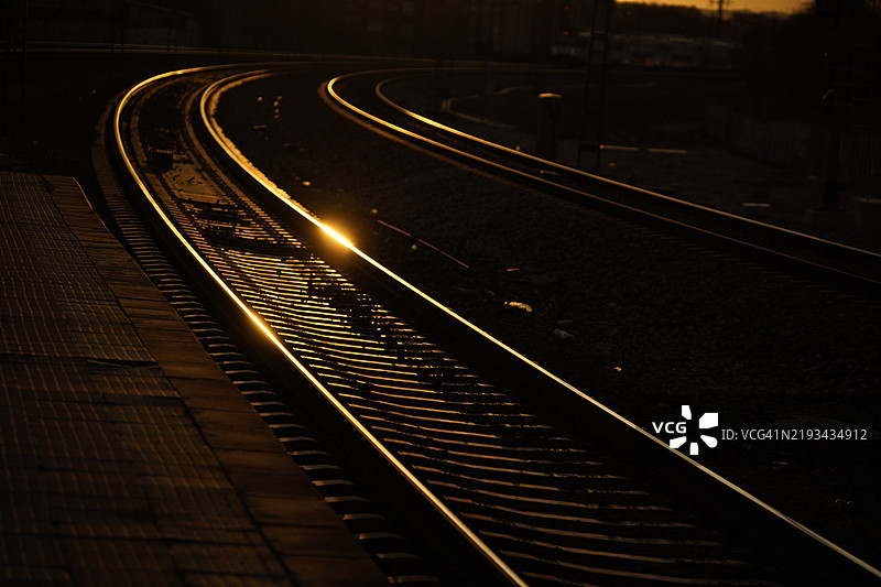 光线照射在弯曲火车的轨道上图片素材