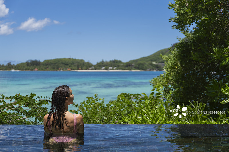 年轻女性在游泳池边放松休息图片素材