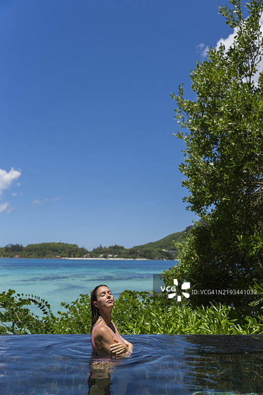 年轻女性在游泳池边放松休息图片素材