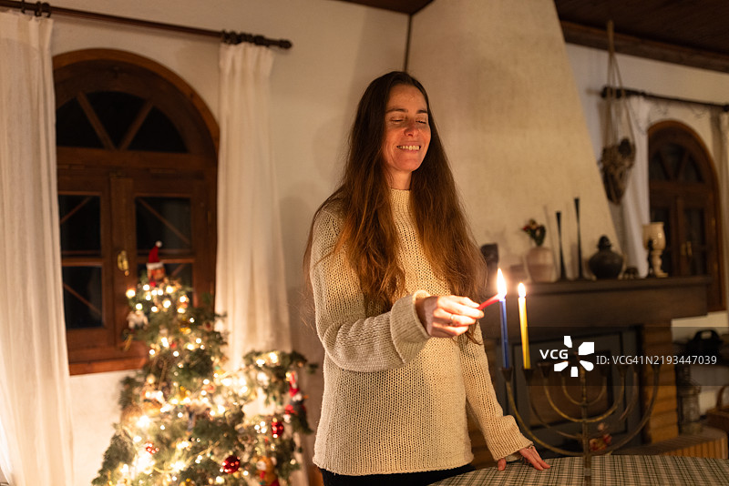 女性在光明节第二晚点燃哈努基亚蜡烛 - 库存照片图片素材