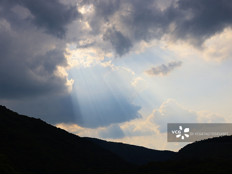 阳光透过云层洒在山脉上图片素材