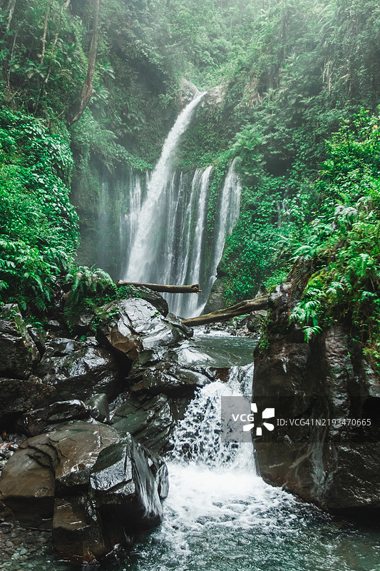 风景如画的热带蒂乌克勒普瀑布，四周环绕着郁郁葱葱的丛林和流淌的小溪图片素材