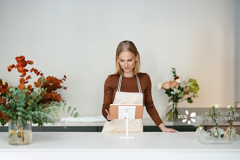 现代花店环境中使用数字平板的花艺师图片素材