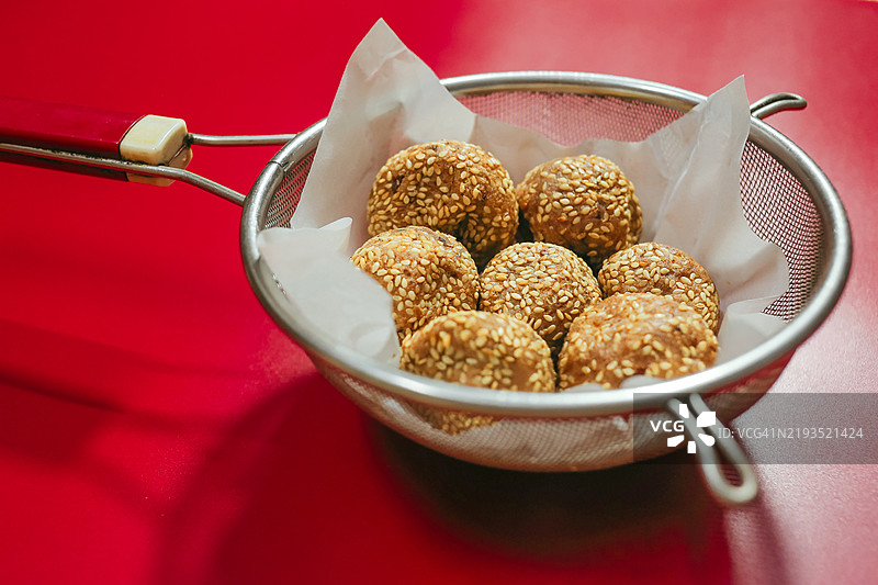 自制的油炸芝麻糯米球，背景为红色图片素材
