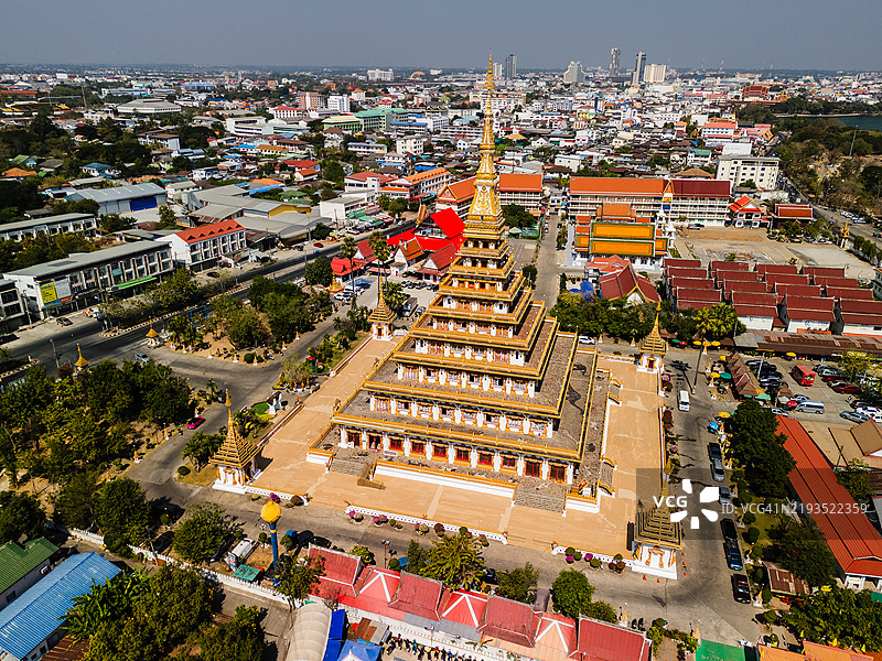 壮观的泰国传统寺庙群的鸟瞰图，金色尖塔环绕着五彩斑斓的建筑和附近的湖泊。图片素材