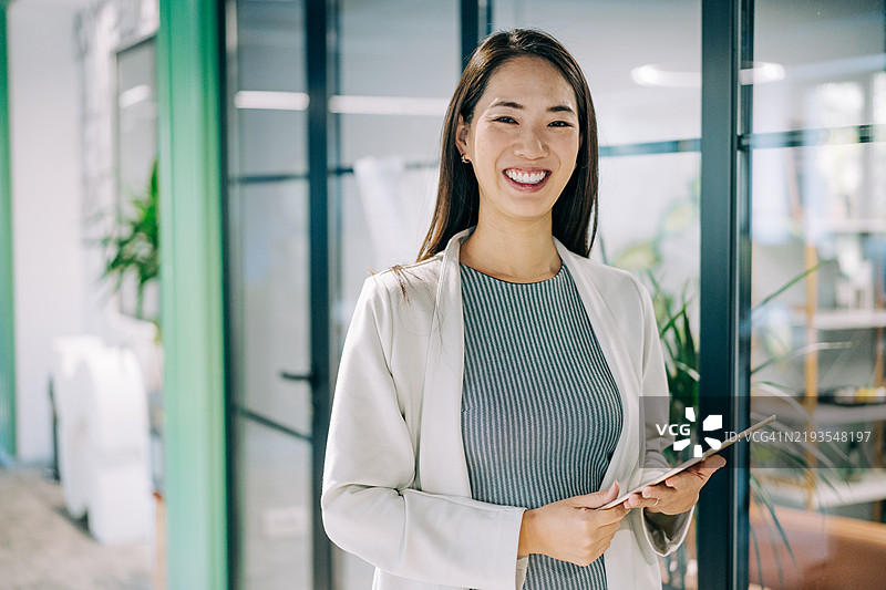 自信的女商人在现代办公室中。图片素材