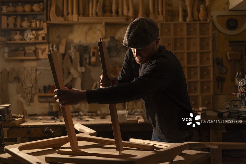 木匠在他的工作坊里用传统技艺组装椅子图片素材