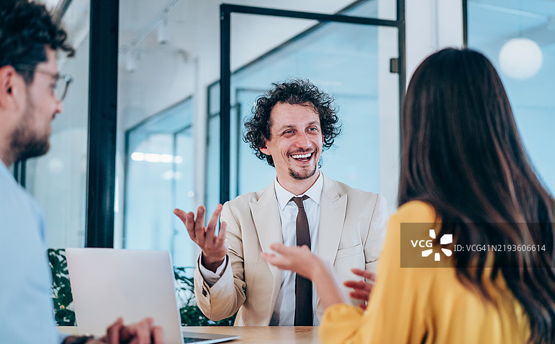 一群商务人士在办公室交谈。图片素材