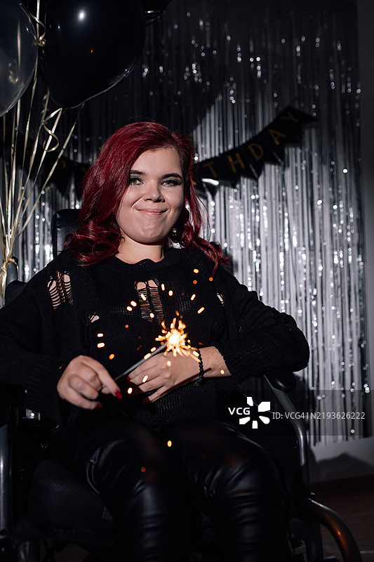 年轻女性在生日派对上享受烟花棒，庆祝生活的美好时刻图片素材