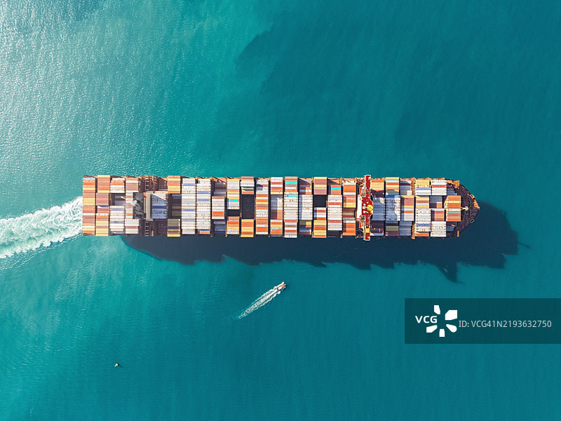 航拍视角的集装箱货船在商业港口码头，适用于商业物流、进出口、航运或货运运输。图片素材