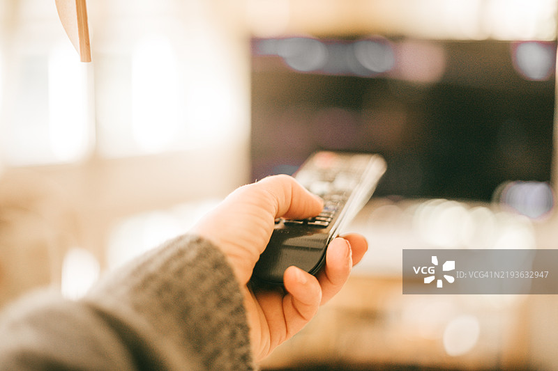 手握遥控器更换电视频道图片素材