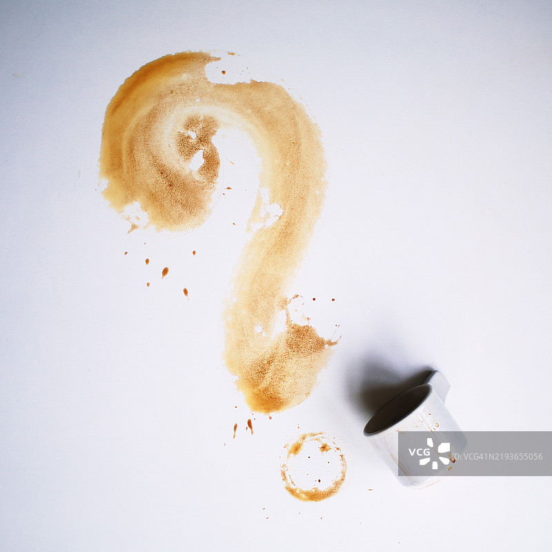 从上方俯视翻倒的咖啡杯与问号形状的画作图片素材