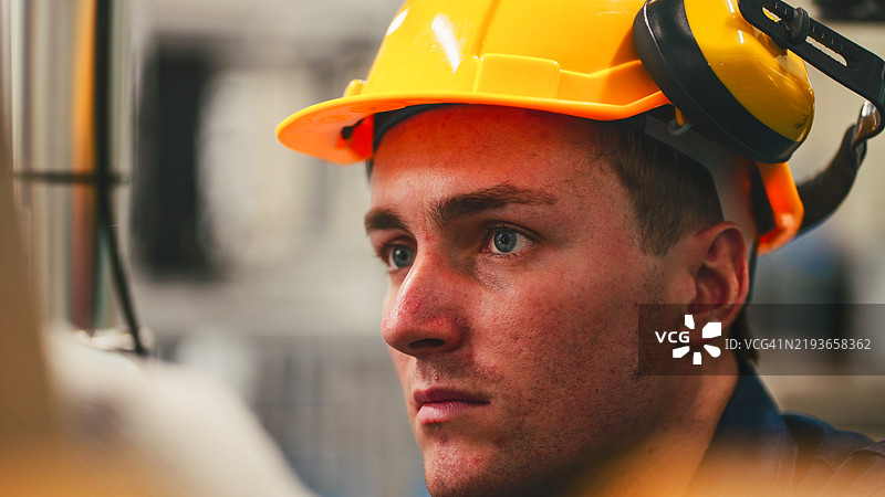 工程师们正在开发自动化生产线，使用机器人部件和应用软件以提高生产效率。对自动化生产线电气部件进行精确工程设计。图片素材