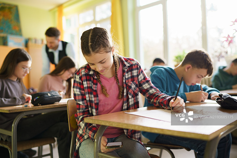 女孩在考试期间使用智能手机图片素材