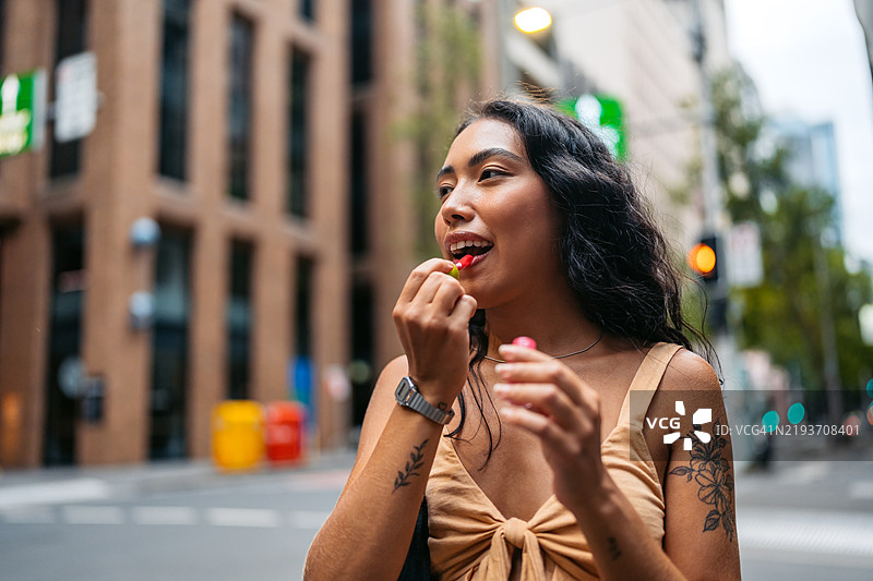 年轻的多种族女性在澳大利亚悉尼的街道上涂口红图片素材