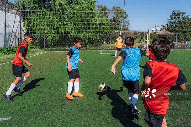 孩子们在阳光明媚的户外享受足球比赛图片素材