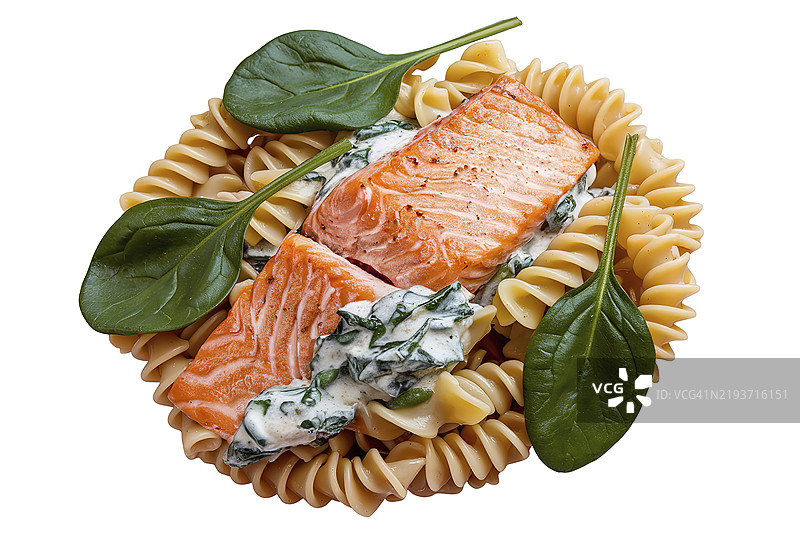一盘三文鱼意大利面，配有奶油菠菜酱和鱼片图片素材