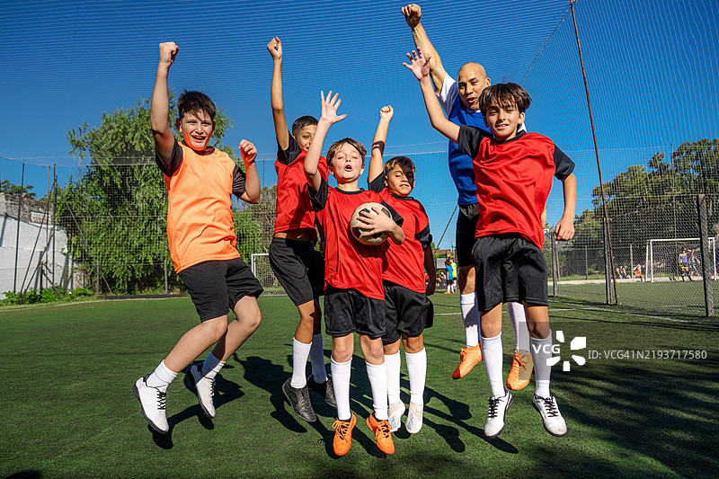 一群孩子在户外足球场庆祝胜利图片素材
