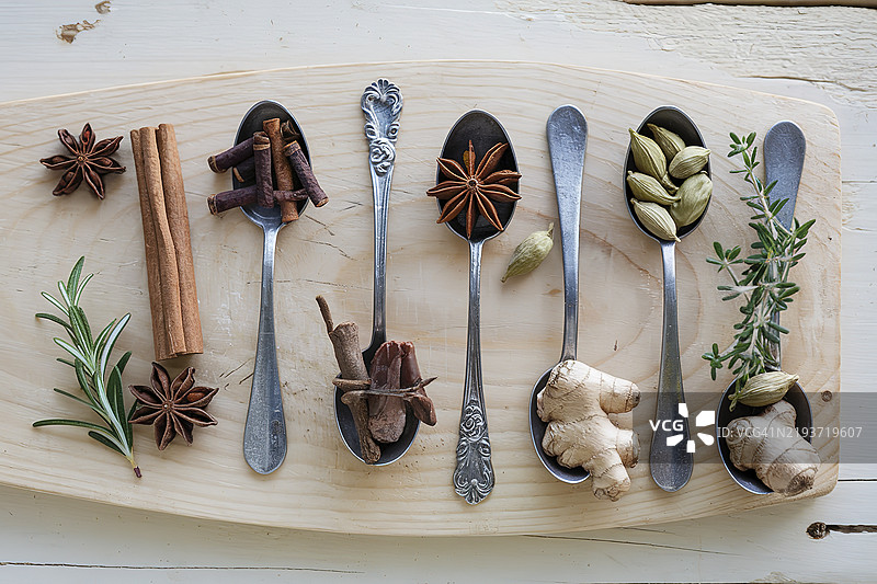 一组各种香料和草药放在旧金属勺子里图片素材