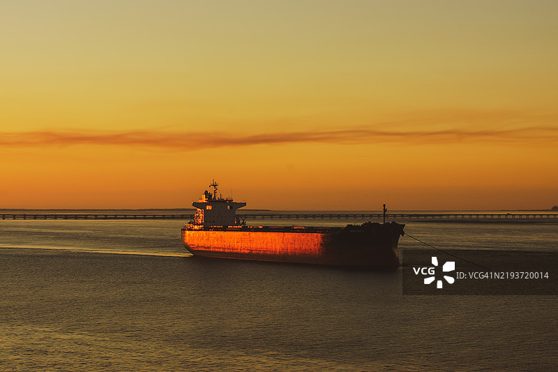 日落时分，俄勒冈州阿斯托里亚的海面上轮廓分明的船只与天空相映成趣。图片素材