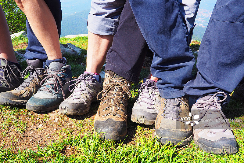 山顶上排成一排的流浪者的靴子和腿部图片素材
