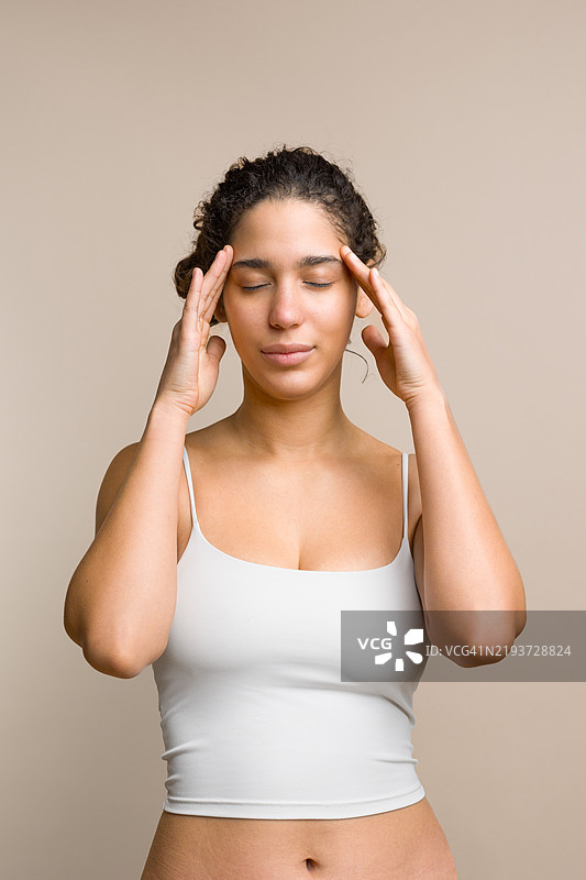年轻女性按摩太阳穴以缓解头痛图片素材