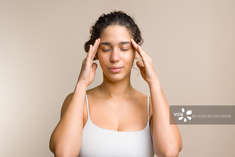 年轻女性因头痛而闭眼捂住太阳穴图片素材