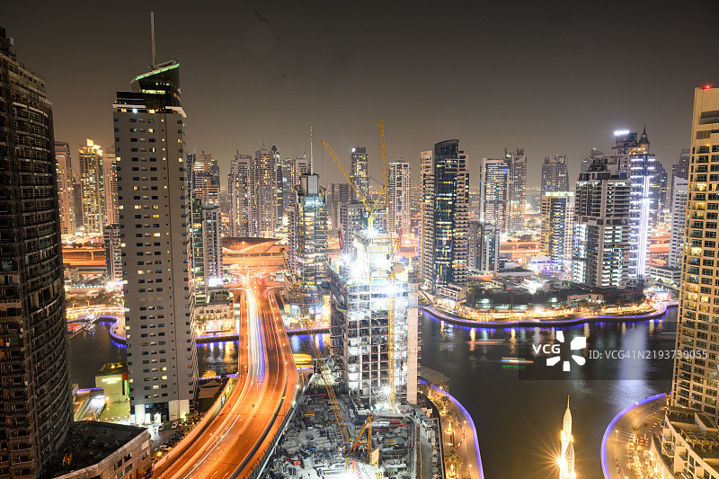 迪拜海滨地区的桥梁长时间曝光，周围环绕着高楼大厦图片素材