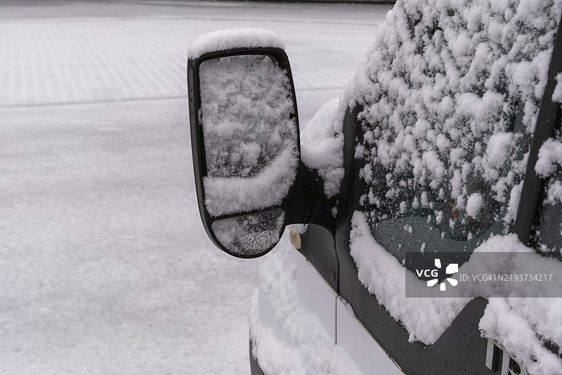 冬季降雪后，新雪在汽车镜子和窗户上积累。图片素材